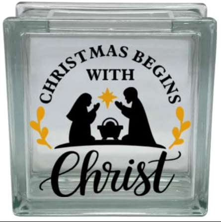 Glass block with a Christmas design featuring silhouettes of a nativity scene and text.