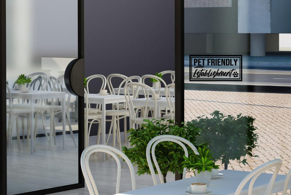 Modern outdoor dining area with white chairs and tables, framed artwork on a wall.