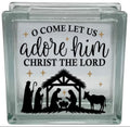 Glass block with nativity scene and text 'O Come Let Us Adore Him Christ the Lord' on a white background
