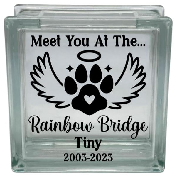 Glass block with paw print design and text 'Meet You At The Rainbow Bridge Tiny 2003-2023' on a white background